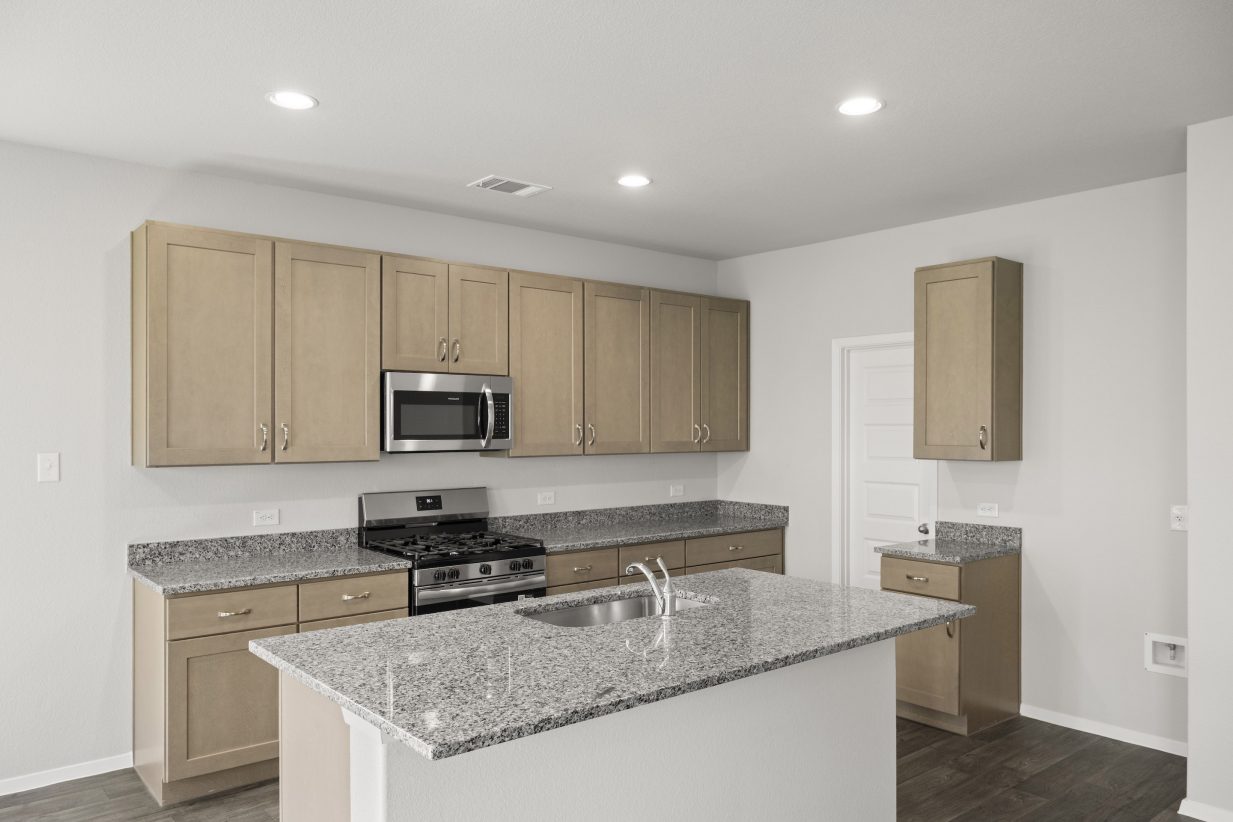 A kitchen with gray marble countertops, gray cabinets, vinyl flooring, a central island, and steel kitchen appliances.