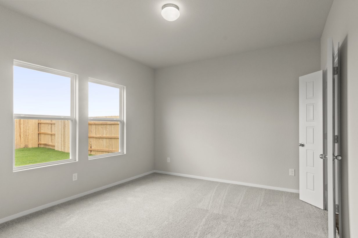 Image of bedroom with light carpet and windows