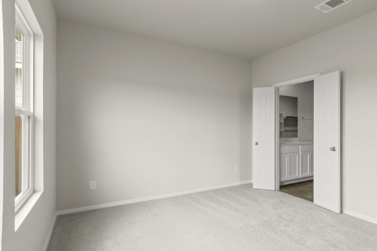 Image of bedroom with open door into bathroom