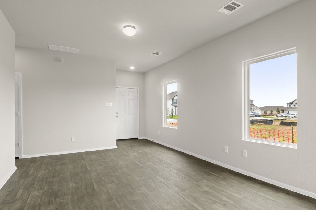Image of inside of home with wood-look floor and windows