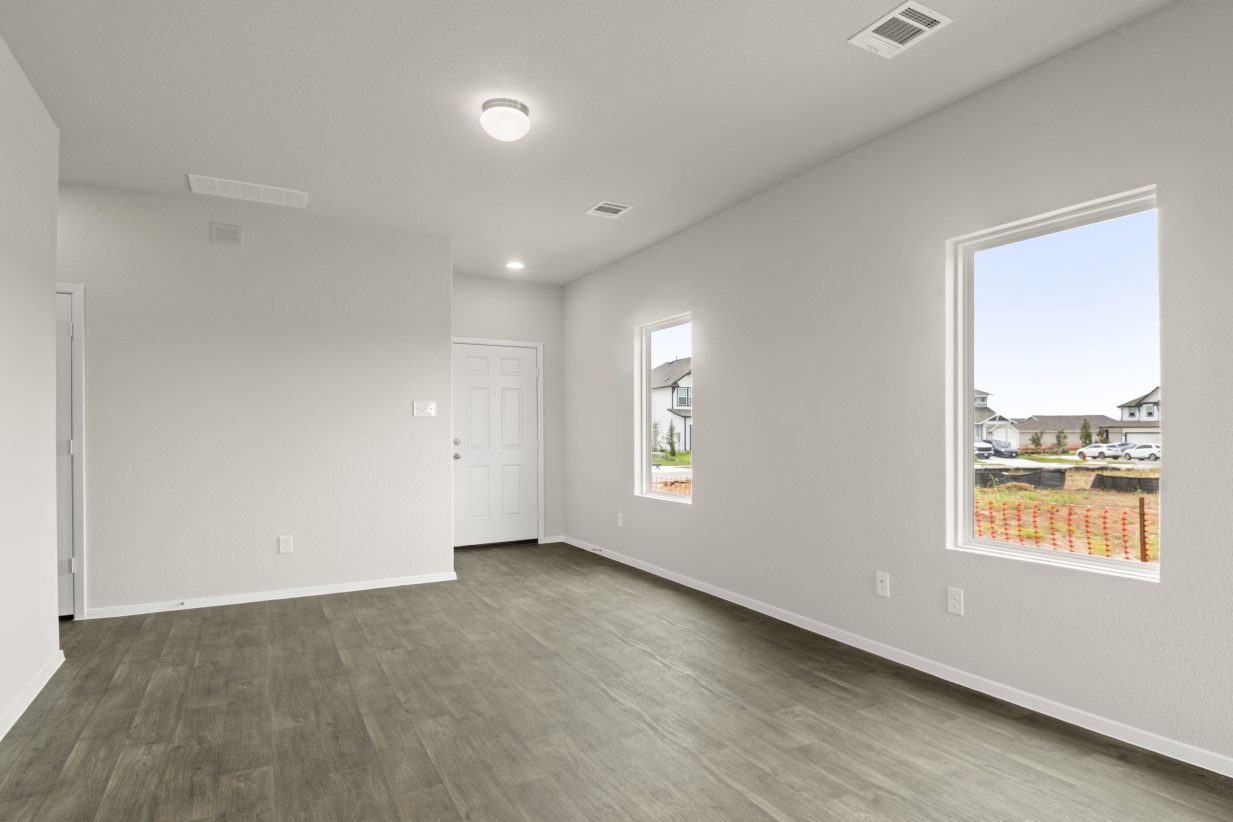 Image of inside of home with wood-look floor and windows