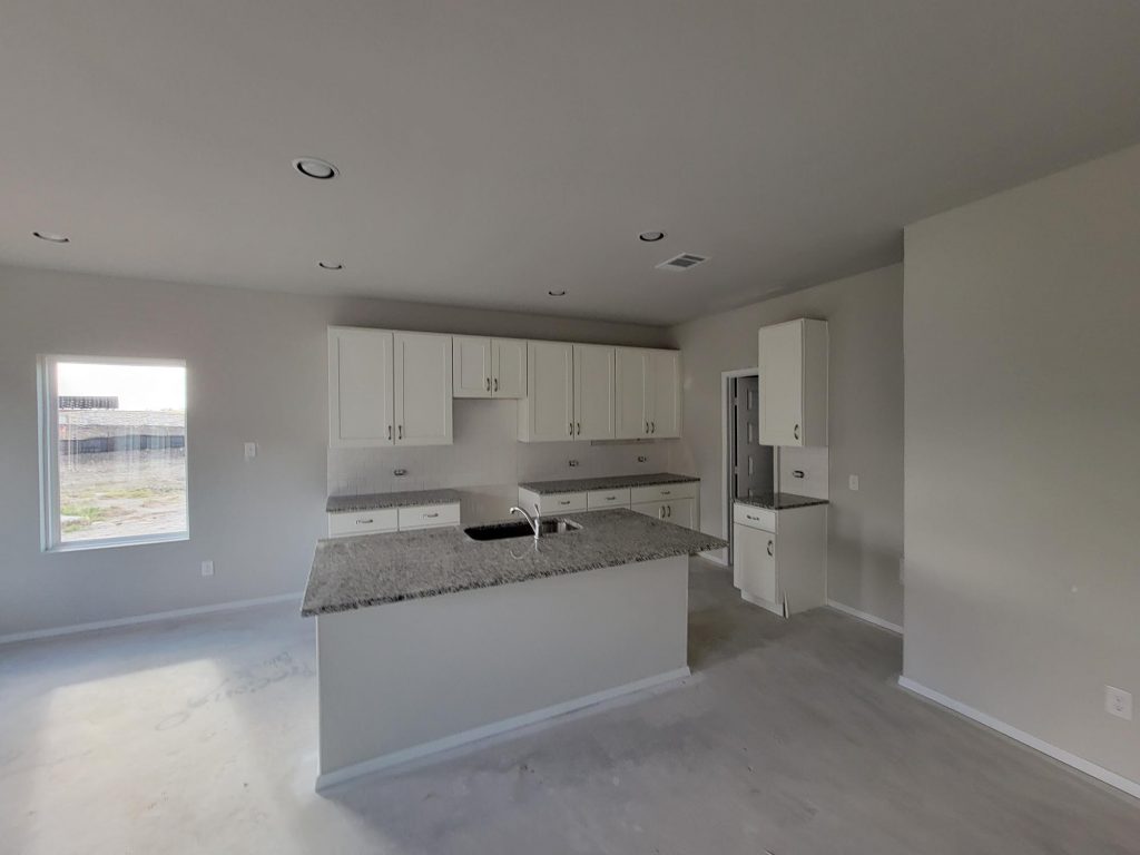 Image of home kitchen under construction with white cabinets and center island
