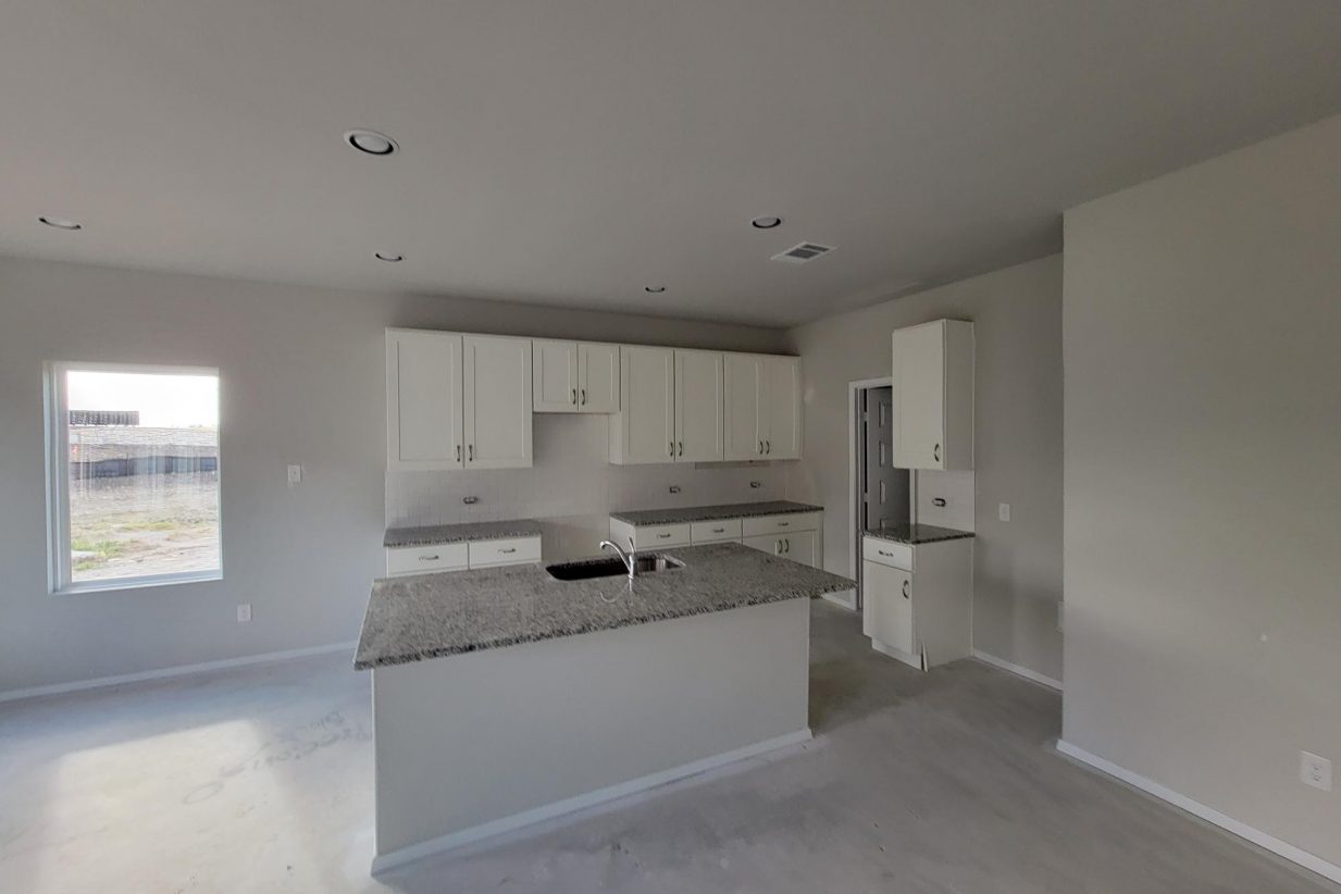 Image of home kitchen under construction with white cabinets and center island